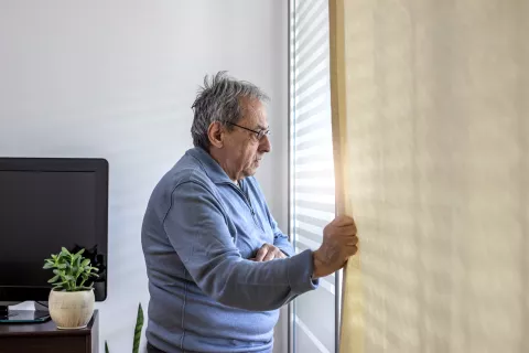 Une personne âgée qui regarde par la fenêtre